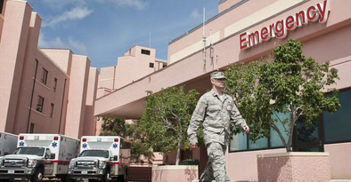 Man in military uniform walking outside a hospital